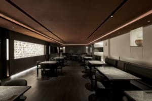 A well-lit restaurant with wooden floors and walls, featuring tables and chairs in a comfortable dining area