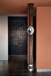 Well-lit Asian bathroom with a wooden wall, tiled floor, and a cat sign