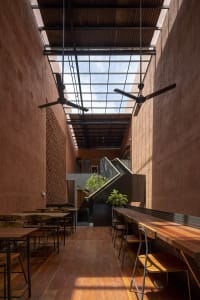 Warm and inviting restaurant interior with dining tables, chairs, and potted plants