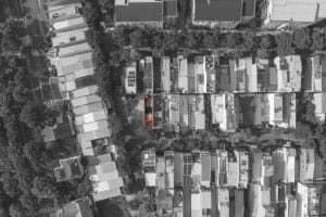 Aerial view of a city street with a large orange structure surrounded by modern buildings made of concrete and glass