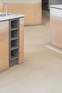 A modern kitchen with two sinks, marble countertops, and a well-equipped layout for cooking and food preparation