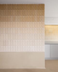 A kitchen with brown tile walls, a tile backsplash, and a sink, creating a warm and inviting atmosphere