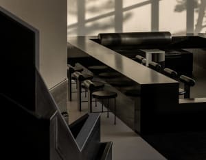 Empty modern restaurant with black tables and chairs arranged in rows, minimalist decoration, and a focus on functionality
