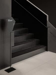 A well-lit stairwell with a wooden staircase, creating a sense of depth and dimension in a functional yet inviting environment