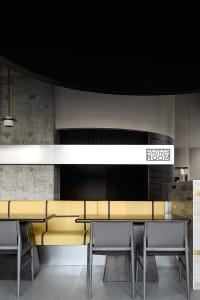 Dining area with multiple tables and chairs in a well-lit restaurant with modern decor
