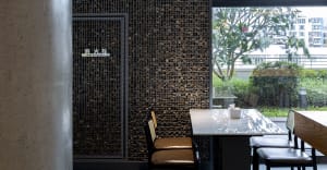 Dining table with two chairs in a restaurant setting, surrounded by marble and elegant decor