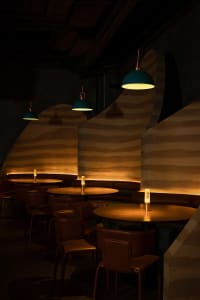 Warm and inviting dining space with wooden tables, chairs, and paneling, featuring candles and a cozy atmosphere