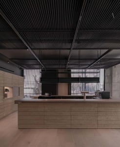 Warm and inviting open kitchen with wooden floors, walls, and countertops, featuring two sinks and a cozy atmosphere
