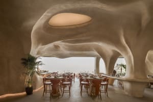A well-lit restaurant with multiple tables and chairs, creating a spacious atmosphere with natural and artificial lighting