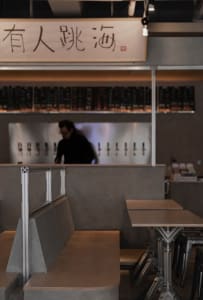 Casual restaurant interior with a bar area, dining tables, and comfortable seating for patrons