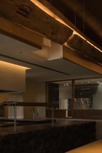 Open kitchen with wooden floors and walls, two sinks, and wooden countertops, giving off a warm and inviting atmosphere