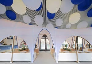 A bright and inviting interior design concept featuring a large white dome with multiple openings and scattered balls of different sizes