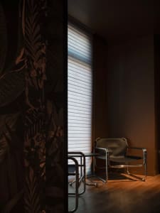 Professional office space with a black leather chair, a large painting on the wall, and a well-organized atmosphere