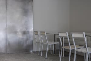 A modern dining area with white chairs and tables arranged around a central dining table, creating a comfortable seating arrangement for guests