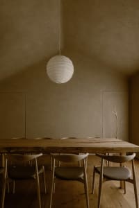 A calm and inviting dining area with a wooden table surrounded by chairs, part of a larger living space