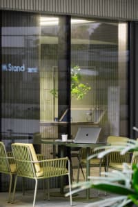 A modern office space with a glass table, three chairs, and a well-organized atmosphere