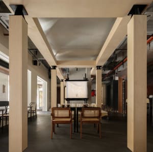 Empty restaurant with wooden floors and walls, featuring a dining table and chairs in a calm and inviting atmosphere