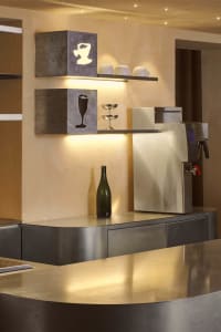 A kitchen area with a countertop featuring bottles, cups, and a vase, suggesting a cozy and functional living space