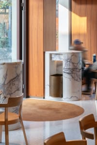 A modern dining space with a marble table surrounded by chairs, featuring a clean and minimalistic design