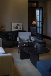Cozy living area with a black table, two chairs, and decorative vases, creating a warm and inviting atmosphere