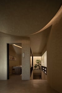 Cozy bedroom with a bed, two potted plants, and a chair, creating a warm and inviting atmosphere