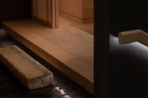 A house with a wooden floor featuring a staircase and two benches, adding warmth and character to the space