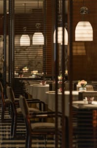 Dining area with white tablecloths, chairs, and a sophisticated ambiance