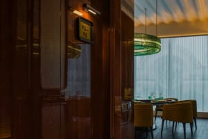 Sophisticated dining area with a large wooden dining table and chairs, wine glasses, and a warm atmosphere