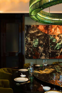 Elegant dining area with a large table, multiple chairs, wine glasses, and decorative bowls and cups, set in a warm and inviting atmosphere