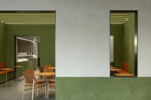 Empty restaurant with green walls, rows of tables, and chairs, creating a clean and inviting atmosphere
