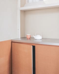 Cozy kitchen with wooden cabinets, a countertop, and a teapot, creating a warm atmosphere