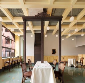 A well-lit dining area with a large wooden table and multiple chairs, creating a comfortable atmosphere for patrons