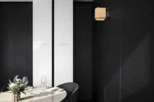 Dimly lit dining area with a table, chairs, and black walls creating an intimate atmosphere