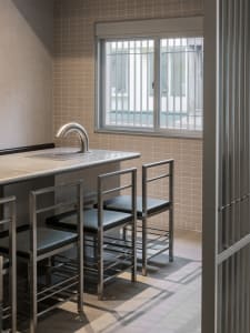 Empty modern kitchen with a large window, a sink, and a dining table with four chairs