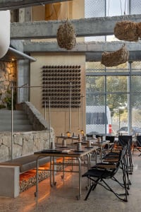 Elegant dining space with tables, chairs, and wine glasses, featuring a sophisticated atmosphere and comfortable seating