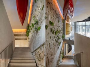 A rustic stone staircase with red and green canoes hung on the walls, adding a decorative element to the space, creating an inviting and comfortable atmosphere