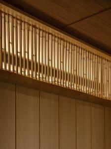 Warm and inviting interior space with wooden walls and ceiling, featuring two large wooden beams on the wall
