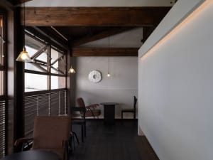 Warm and inviting living space with wooden floors and walls, featuring multiple chairs and dining tables, with a focus on comfort and functionality