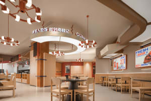 A restaurant interior with wooden tables and chairs, creating a cozy atmosphere for dining