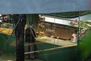 A casual dining kitchen scene with green walls, a counter, and various kitchen items, conveying a fresh and vibrant atmosphere