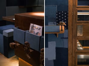 Cozy living space with wooden floors, a desk, denim couch, and various furniture pieces, creating a comfortable atmosphere