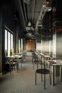Empty modern restaurant interior with tables and chairs arranged throughout the space, creating a clean and well-organized atmosphere