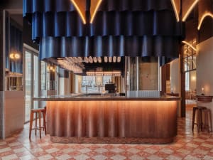 Cozy bar area with a wooden countertop, bottles, and a large curtain covering the entrance