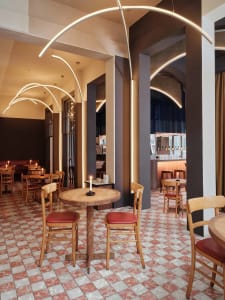 cozy restaurant interior with wooden floors, tables, chairs, and wine glasses