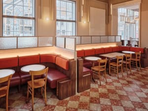 Warm and inviting restaurant interior with wooden tables and chairs, natural light, and a rustic atmosphere