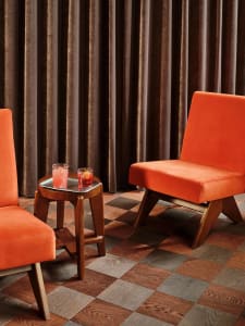 A cozy living area with a fabric chair and wooden table, set up for conversation or relaxation