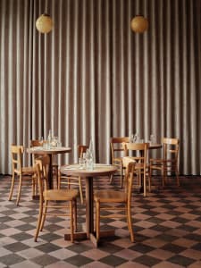 A dining area with several wooden chairs arranged around a table, set up for a meal in a warm and inviting atmosphere
