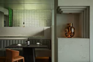 Sophisticated dining area with a black table, dark wood accents, and a wine bottle and glasses