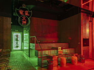 Vibrant Asian restaurant interior with red and green neon sign, tiled flooring, and modern-traditional decor