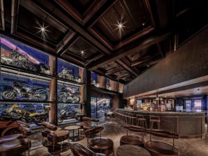 A casual bar with motorcycles on display, surrounded by chairs and a welcoming atmosphere